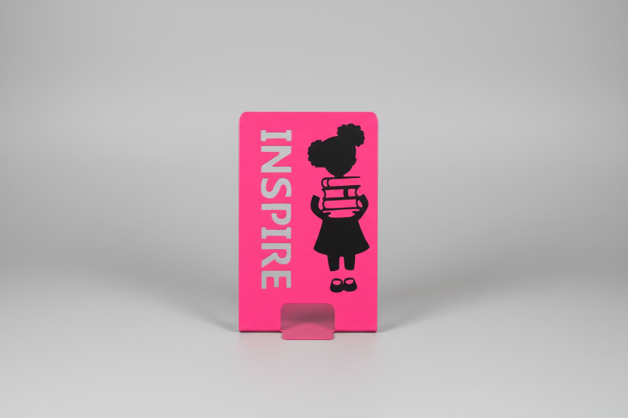 Pink stand with black silhouette of a person holding a book and the word 'INSPIRE' on a black background with text.