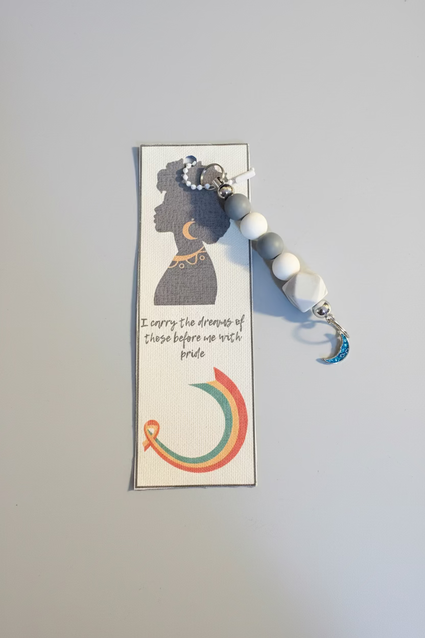 Keychain with rainbow design on a card against a black background with text