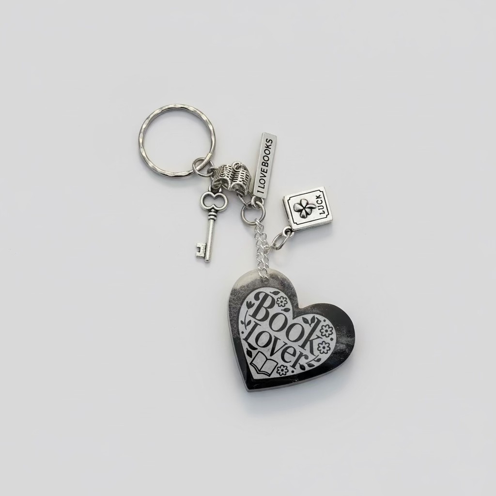 Heart-shaped keychain with 'BOOk LOVER" on a textured surface